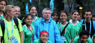 Thomas Bach több nemzet sportolóival a faluban